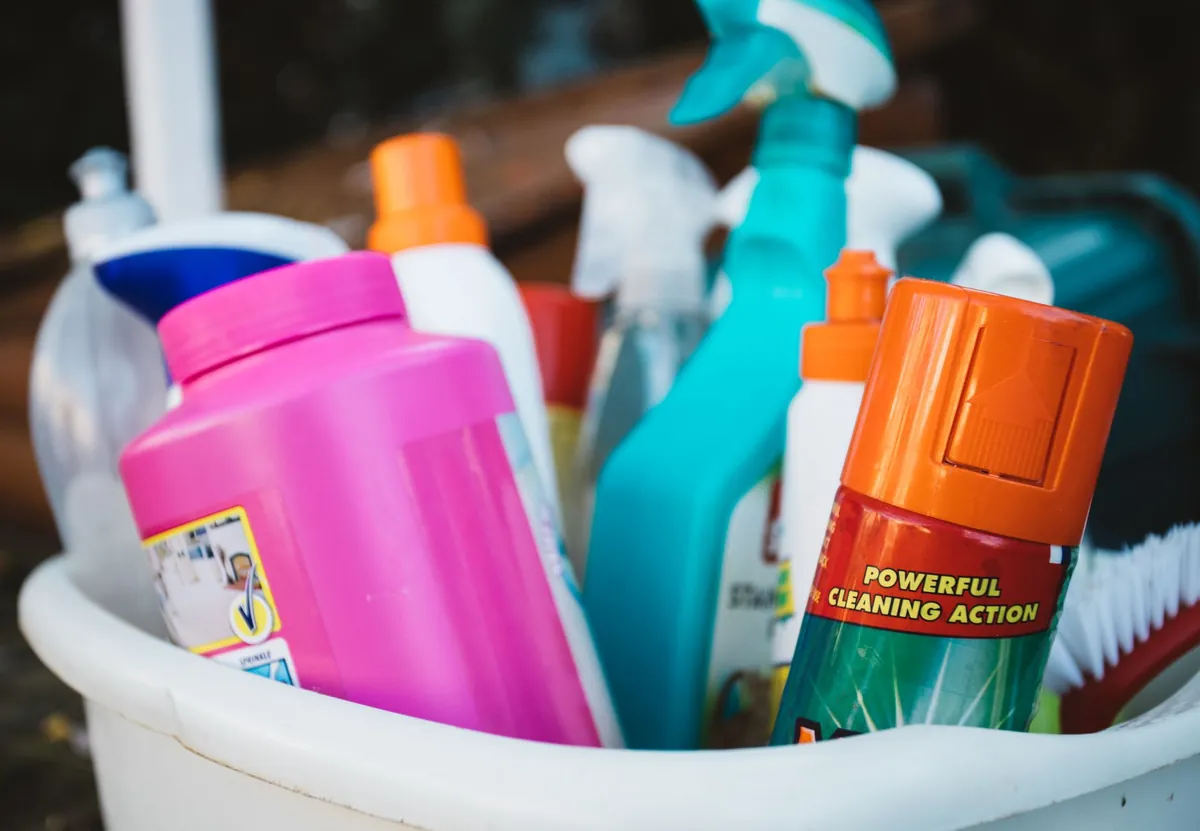 Productos de limpieza de colores en un balde
